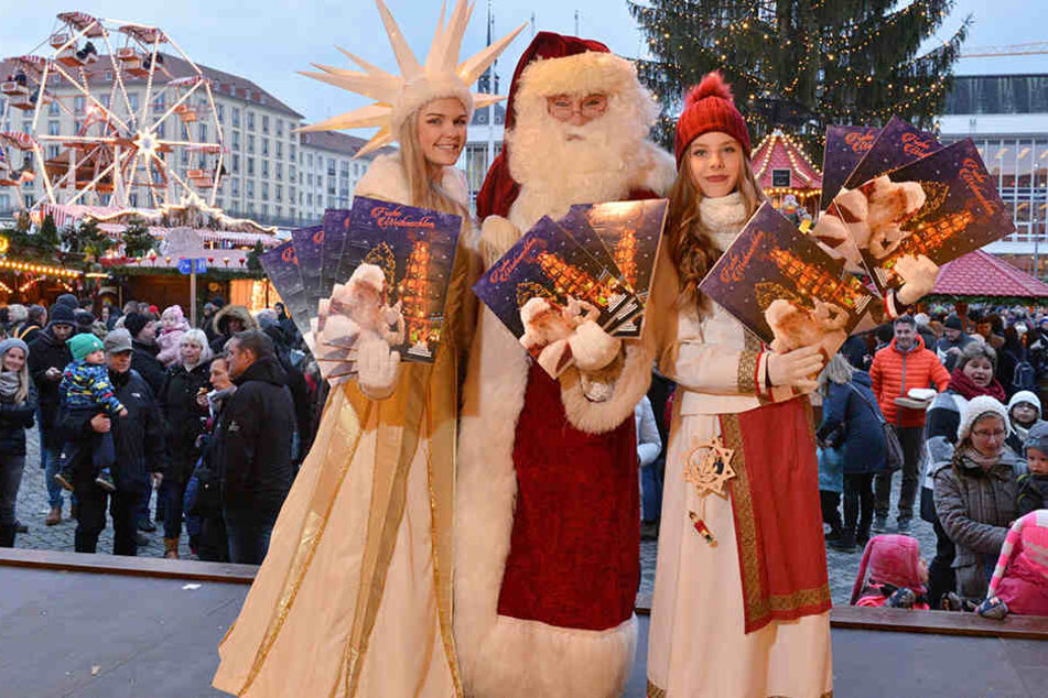 So lieben ihn die Kinder: Steffen Urban (55) 2017 als Weihnachtsmann auf dem Striezelmarkt mit Sternmädchen Linda und Spielzeugmacherin Joel (r.).