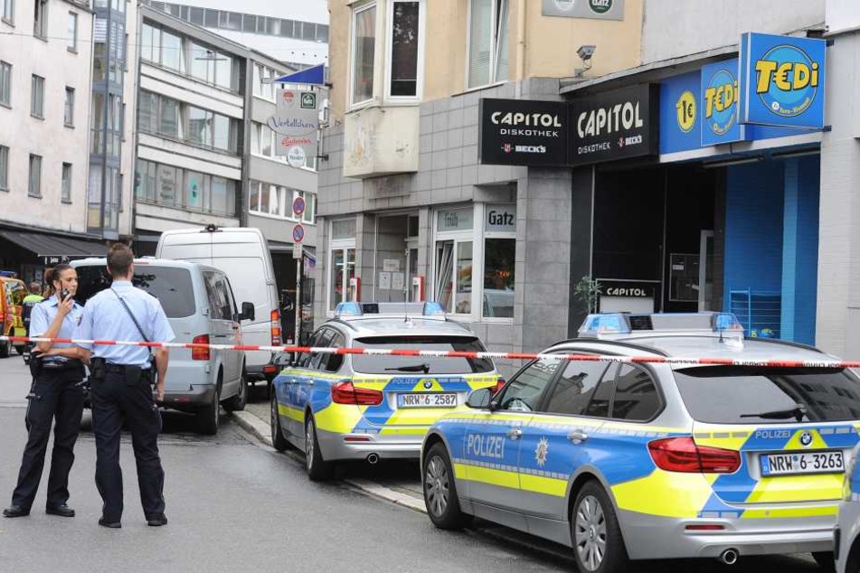Polizisten stehen auf einer Straße in Wuppertal, nachdem bei einer Messerstecherei in der Nähe des Wuppertaler Hauptbahnhofs ein Mensch getötet worden ist.