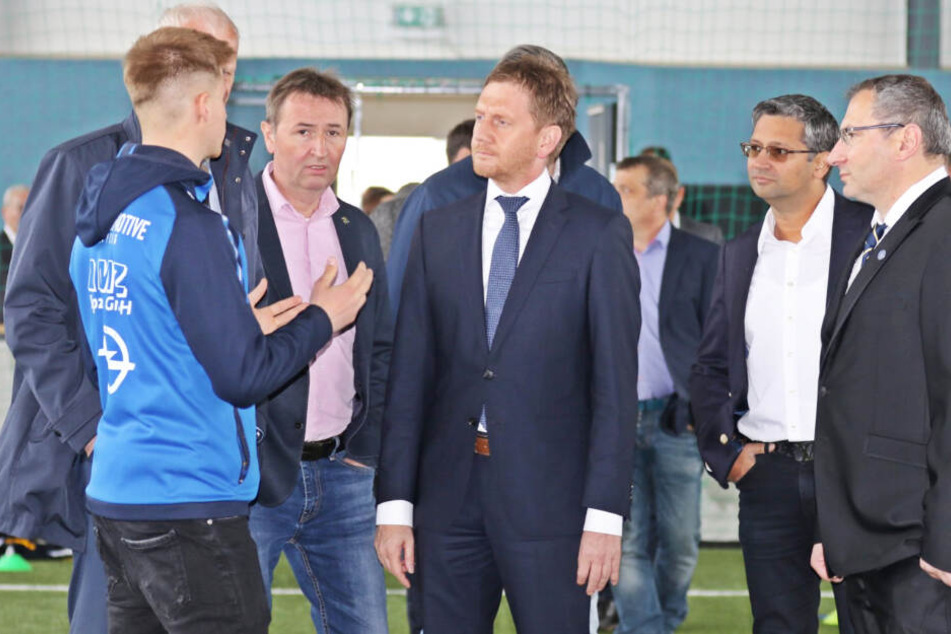 Sachsens Ministerpräsident Michael Kretschmer (Mitte) überzeugte sich persönlich vom Zustand der neu sanierten Trainingshalle und des Kunstrasenplatzes.