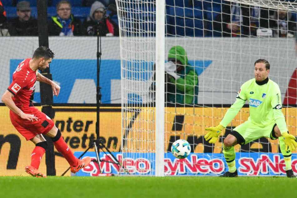 Leverkusens Lucas Alario (links) schießt an TSG-Torwart Oliver Baumann vorbei - und erzielt das 0:3 für Leverkusen.