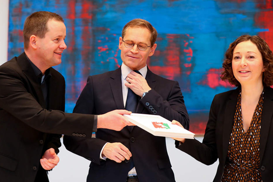 Klaus Lederer (Linke) (l-r), Berlins Regierender Bürgermeister Michael Müller (SPD) und die Ramona Pop (Grüne), tauschen nach der Unterzeichnung den Koalitionsvertrag von SPD, Linken und Grünen.