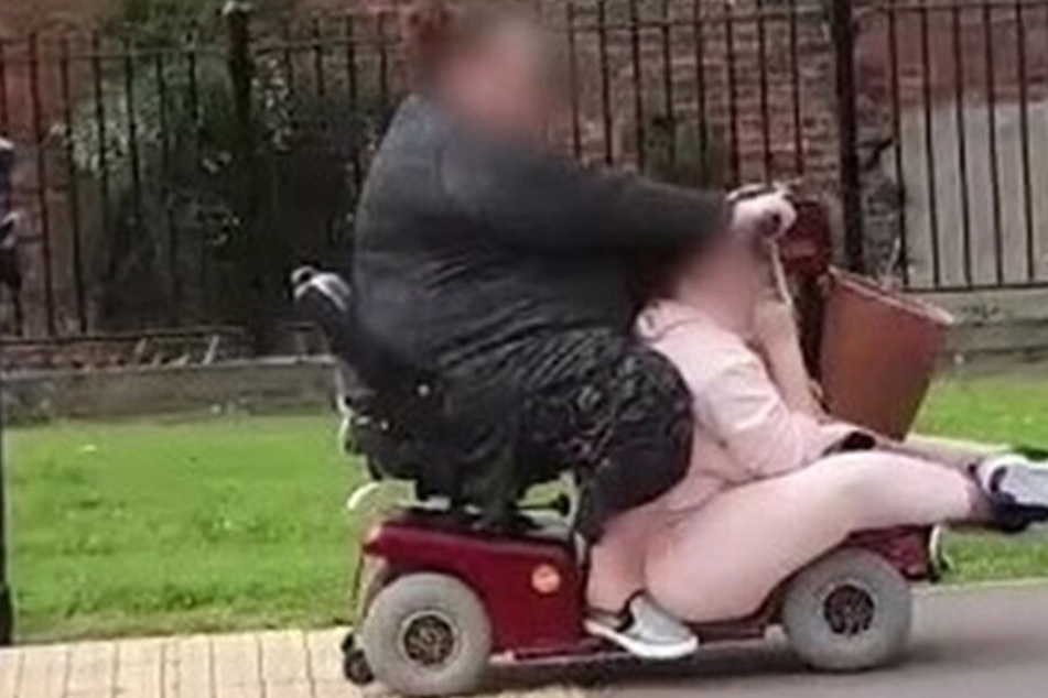 Kurios! Zwei Frauen quetschen sich in einen Roller, um einkaufen zu fahren