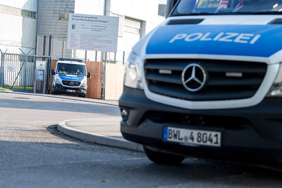 Vor dem Gebäude sichern mehrere Polizeiwagen den Prozess.