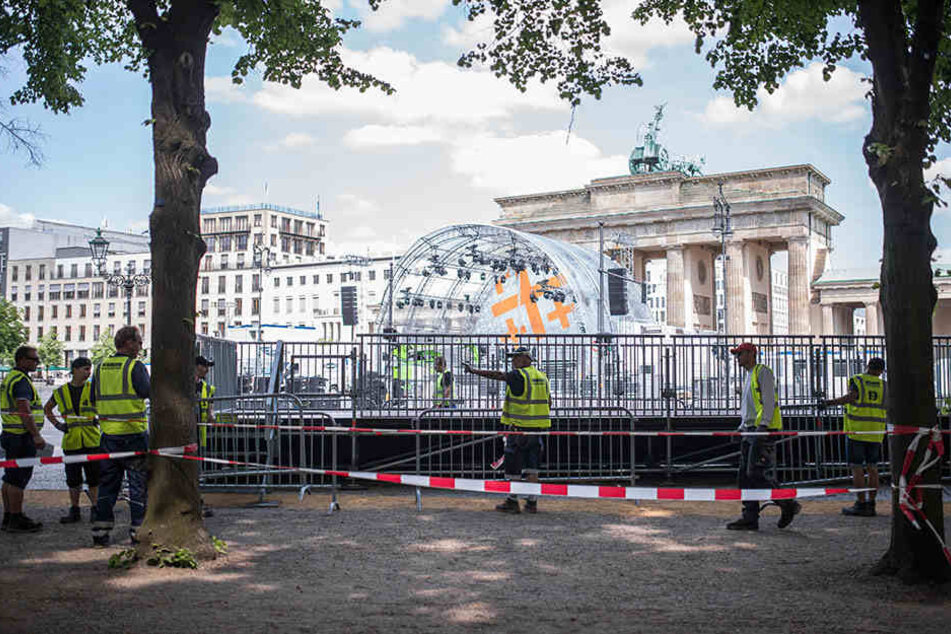 Bauarbeiter stellen vor dem Brandenburger Tor in Berlin Straßenabsperrungen in Vorbereitung auf den Evangelischen Kirchentag auf.