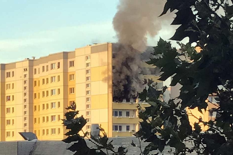 Dichter Qualm dringt aus der brennenden Wohnung in der achten Etage.