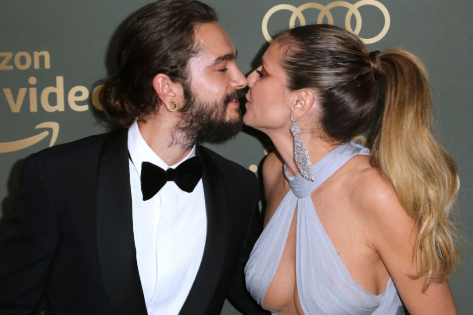 Tom Kaulitz und Heidi Klum küssen sich vor der Kamera.