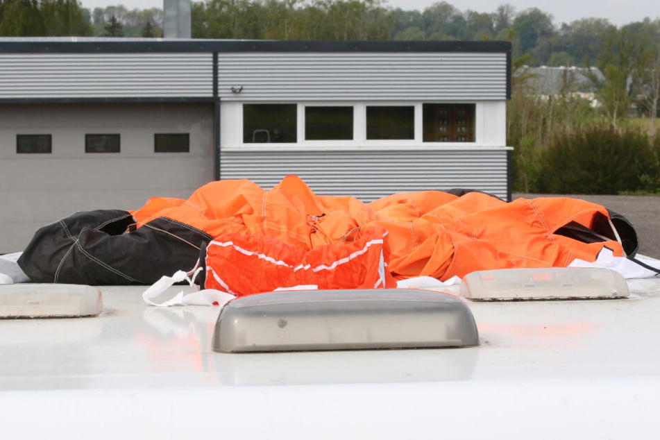 Der Fallschirm eines der Verunglückten liegt auf dem Dach eines Wohnmobils auf dem Parkplatz am Flugplatz.