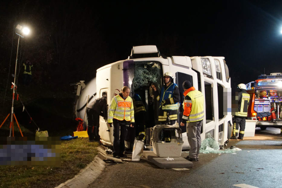 Einsatzkräfte am Lastwagen. Links unter einer Plane liegt der Leichnam des Fahrers.