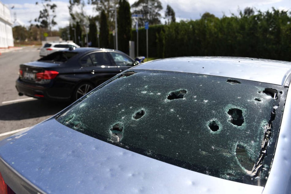 Von Hagel beschädigte Autos stehen vor dem alten Parlamentsgebäude in Canberra geparkt.