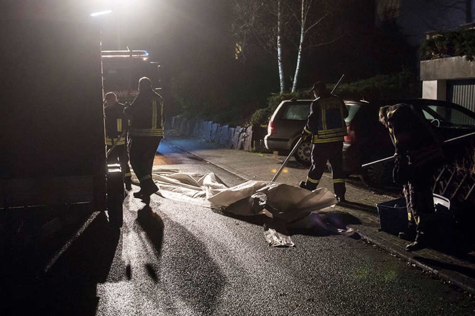 Mitarbeiter der Feuerwehr beseitigen Spuren am Tatort.