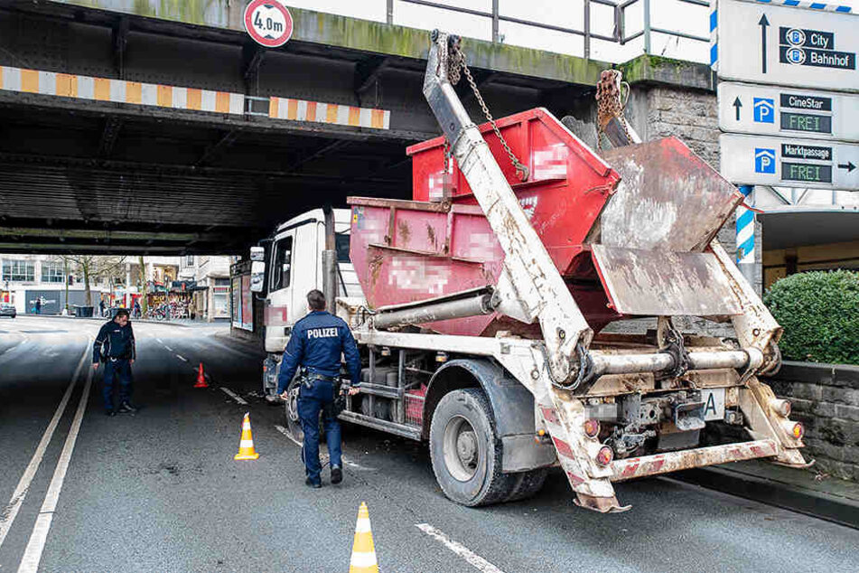 An der Eisenbahnbrücke, am Übergang zwischen Jöllenbecker Straße und Feilenstraße, bliebt der Muldenkipper mit seinen Tragarmen stecken.