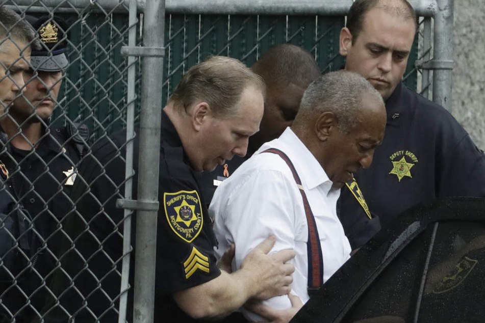 US-Entertainer Bill Cosby (Mitte) wird von Sicherheitskräften aus dem Gericht zu einem Auto geführt.