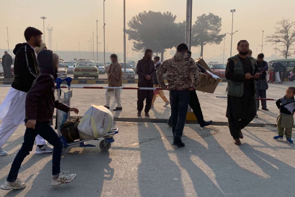 Die aus Deutschland abgeschobenen Afghanen verlassen nach ihrer Ankunft den Flughafen.