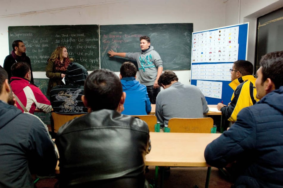 Der Syrer Shadi Tello (l. n. r.) und die Schüler Diana Sosin und Florian Wendland unterrichten in Eisenhüttenstadt Asylbewerber im Fach Deutsch.