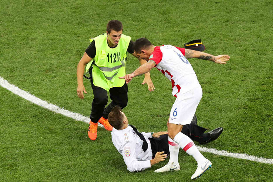Kroatiens Dejan Lovren (r.) und ein Ordner stoppen einen Flitzer der Pussy-Riot-Gruppe.