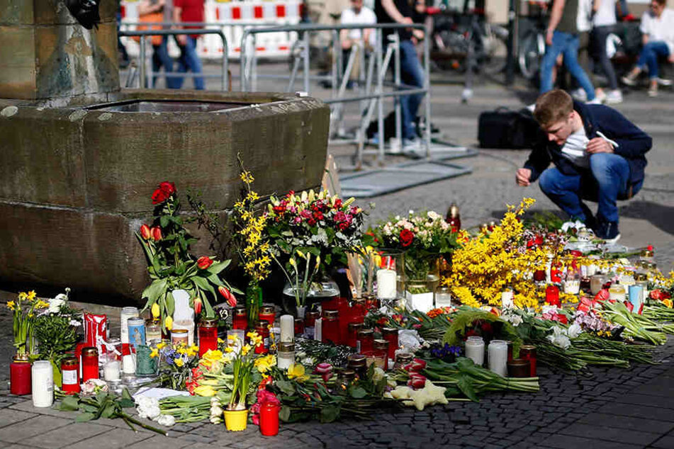 Ein Mann legt am Tatort in Münster Blumen ab.