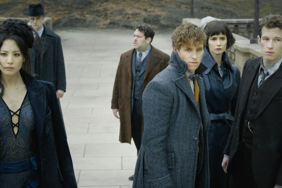 Nagini (l., Claudia Kim) Jacob Kowalski (Dritter von l., Dan Fogler), Newt Scamander (Dritter von r., Eddie Redmayne), Tina Goldstein (Zweite von r., Katherine Waterston) und Theseus Scamander (Callum Turner) stehen schwere Zeiten bevor.