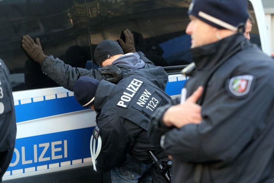 Polizisten kontrollieren am Rande einer Demo einen mutmaßlichen Rechtsextremen.