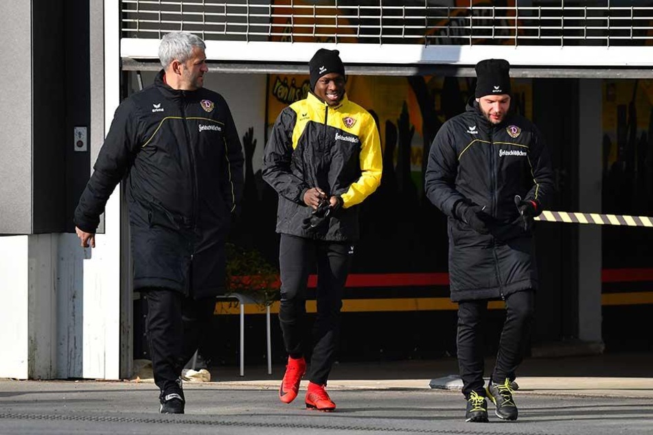 Gut gelaunt und flankiert von Co-Trainer Peter Németh (l.) und Physio Alexander Schurig (r.) läuft Moussa Koné zu seiner ersten Einheit in den Großen Garten.