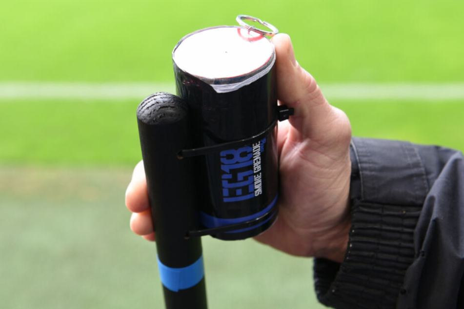 Ein Fan hält eine Rauchgranate in der Hand.
