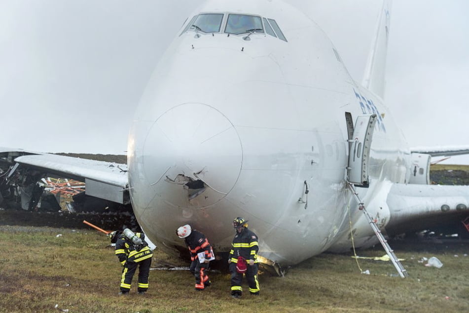 Rettungskräfte stehen vor einem Frachtflugzeug, das von der Landebahn am Halifax Stanfield International Airport gerutscht ist.