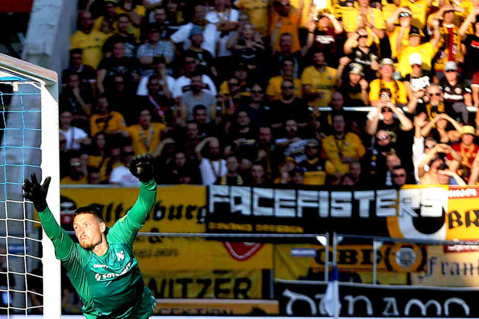 Während Darmstadt Keeper Stritzel fliegt, schauen die Dynamo-Anhänger auf das Spielfeld.