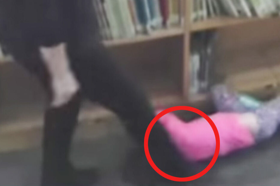 Wenig später sieht man, wie die Lehrerin auf die 5-Jährige, die am Boden liegt, eintritt.