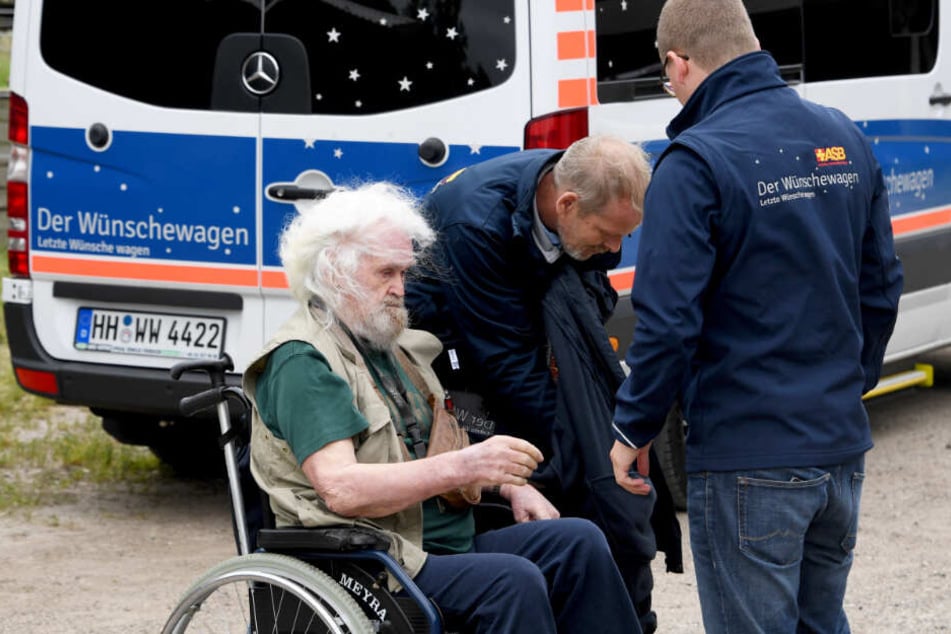Helfer des ASB bringen Edzard Riek mit dem Wünschewagen zum Pferdehof.