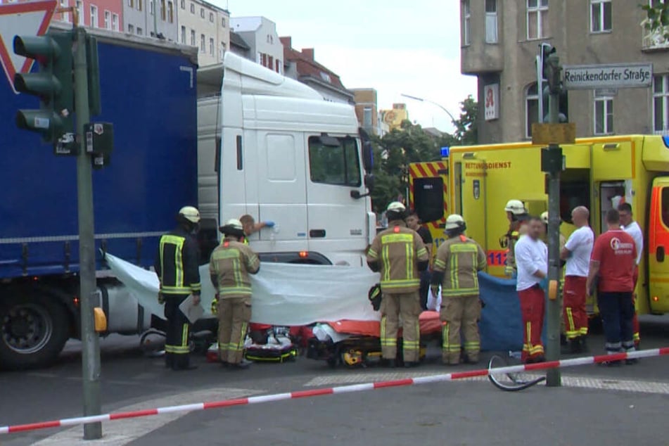 Rettungskräfte decken den Verletzten mit einer Plane ab.