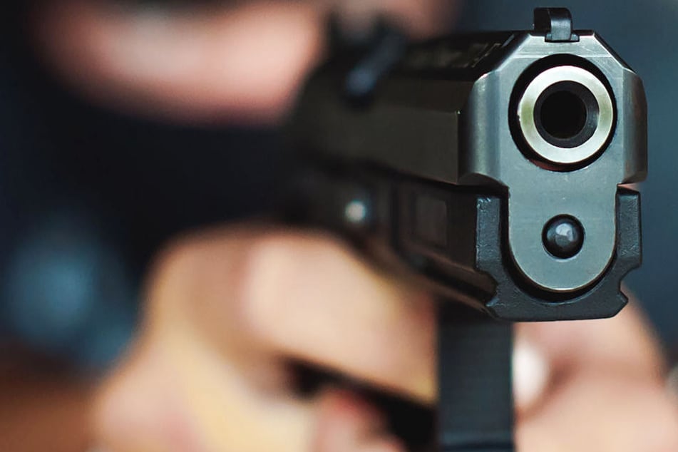 Der Räuber hatte eine Schusswaffe dabei und drohte damit (Symbolbild).