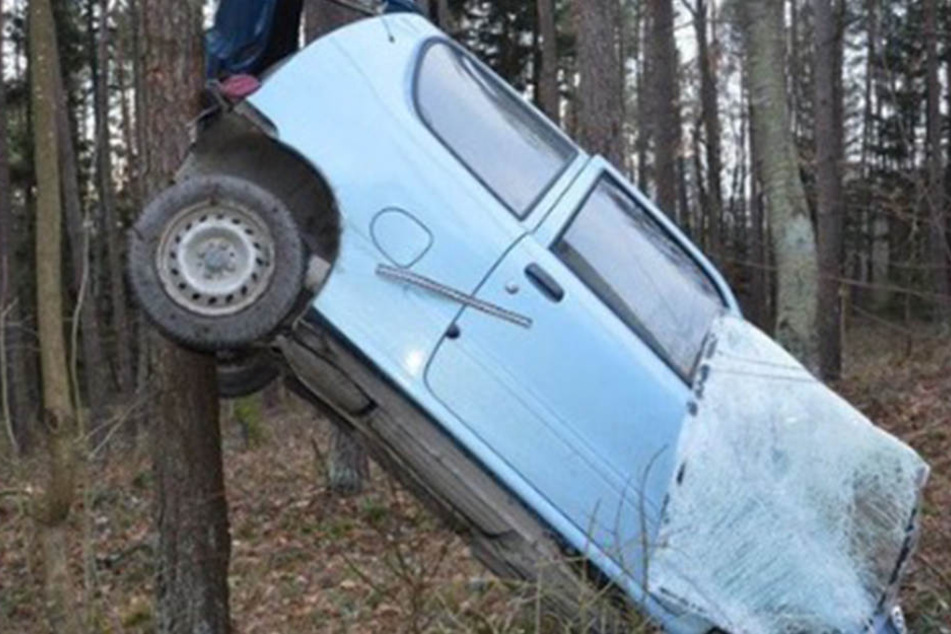 Der blaue Fiat hängt nach dem Unfall an einem Baum.
