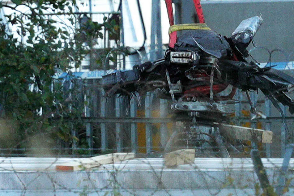 Ein Kran hebt Wrackteile des Helikopters in die Höhe.