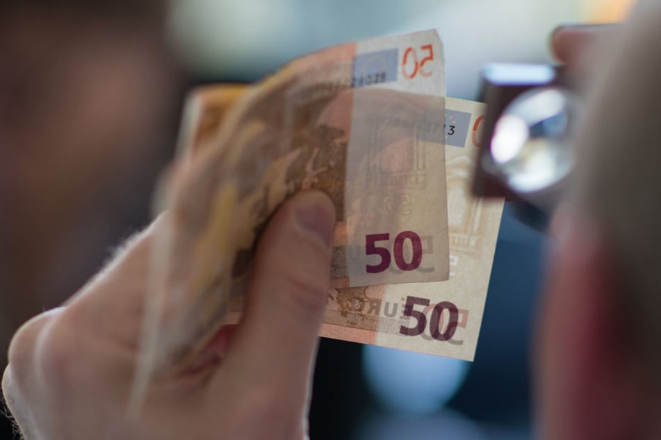 Ein Experte überprüft 50-Euro-Scheine auf ihre Echtheit.