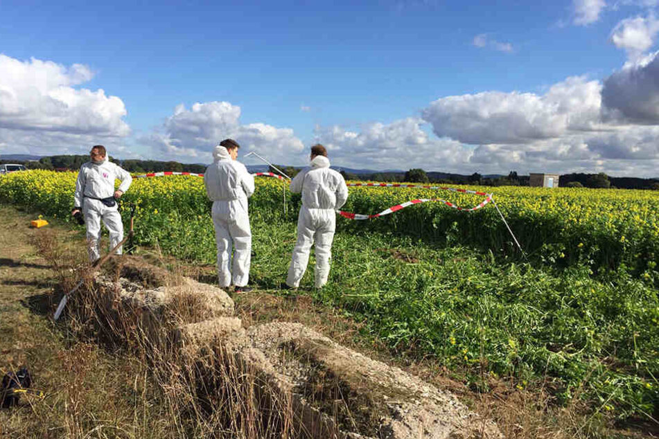 Spezialisten der Spurensicherung suchen die Tatwaffe - ein Messer - in einem Feld nahe des Tatorts.