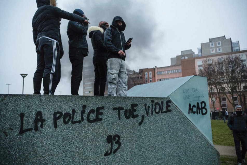 Demonstranten stehen am Sonnabend in Bobigny bei Paris auf einem Container, um gegen Polizeigewalt zu demonstrieren. Auf dem Container steht "Die Polizei tötet, vergewaltigt".