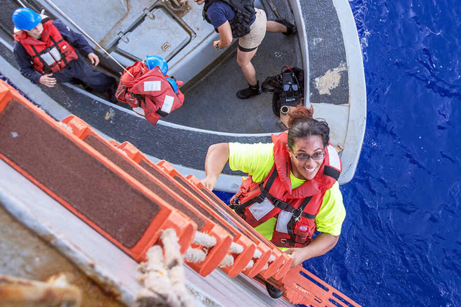 Matrosen der USS Ashland begrüßen nach der Rettung Hund Zeus und seine Besitzerin Tasha Fuiaba an Bord.