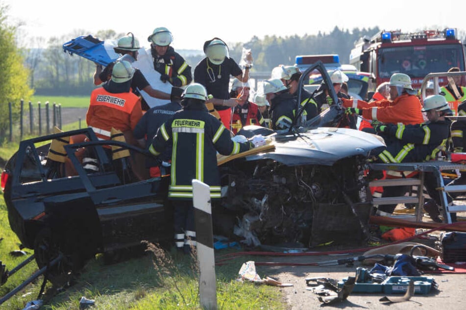 Einsatzkräfte befreien den Fahrer aus dem Unfallwagen.