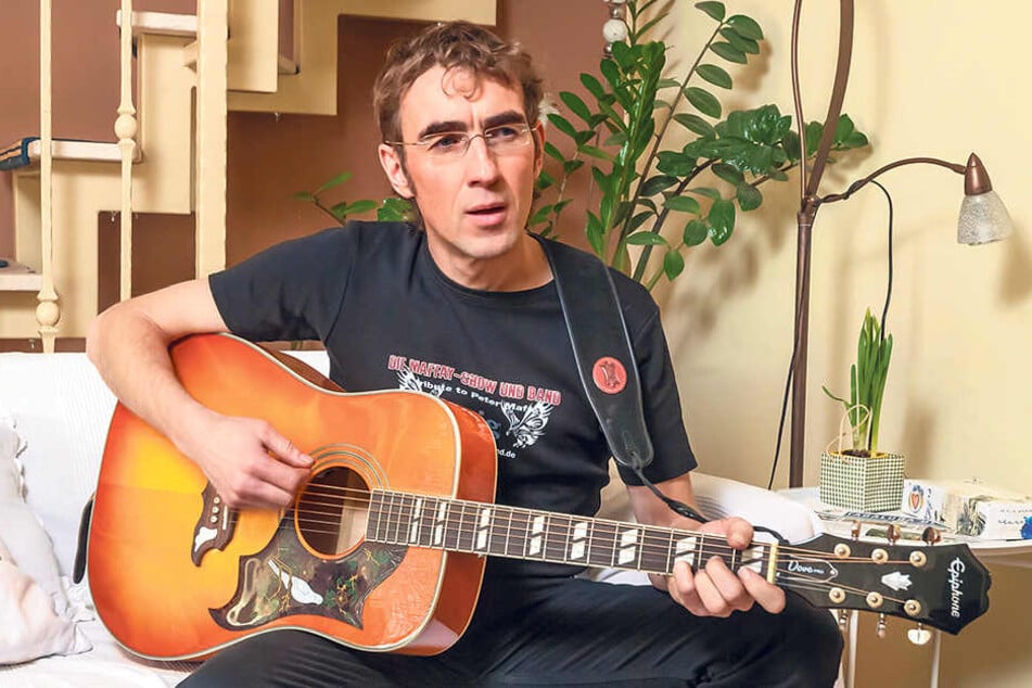 In zivil: Steven Gärtner (44) zu Hause. Auch hier ist seine Gitarre immer zur
Hand.