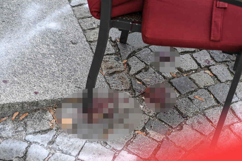 Der Bereich um einen Stuhl ist im abgesperrten Tatort auf dem Marienplatz markiert. Darunter ist Blut von der Messerstecherei zu sehen.