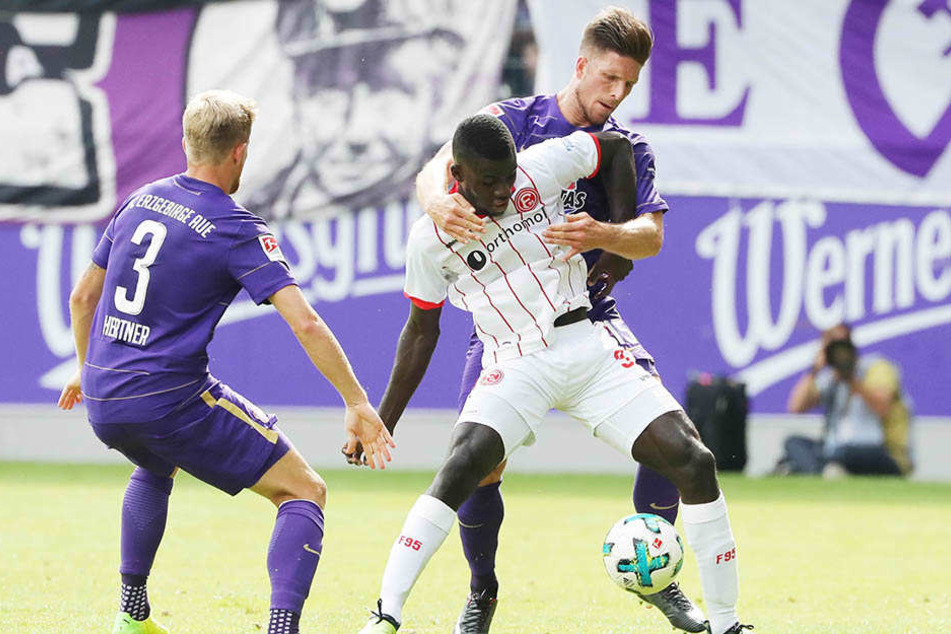 Ihlas Bebou (m.) wird von Sebastian Hertner (l.) und Dennis Kempe (r.) umringt.