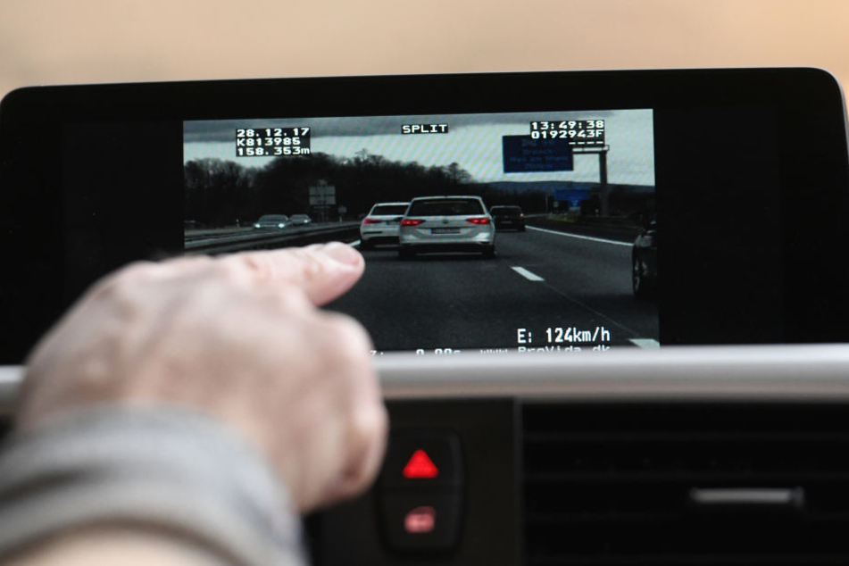 Ein Beamter der Verkehrspolizei in Freiburg schaut sich auf dem Monitor des Videomessfahrzeuges einen Autofahrer an, der beim Drängeln auf der Autobahn gefilmt wurde. (Archivbild)