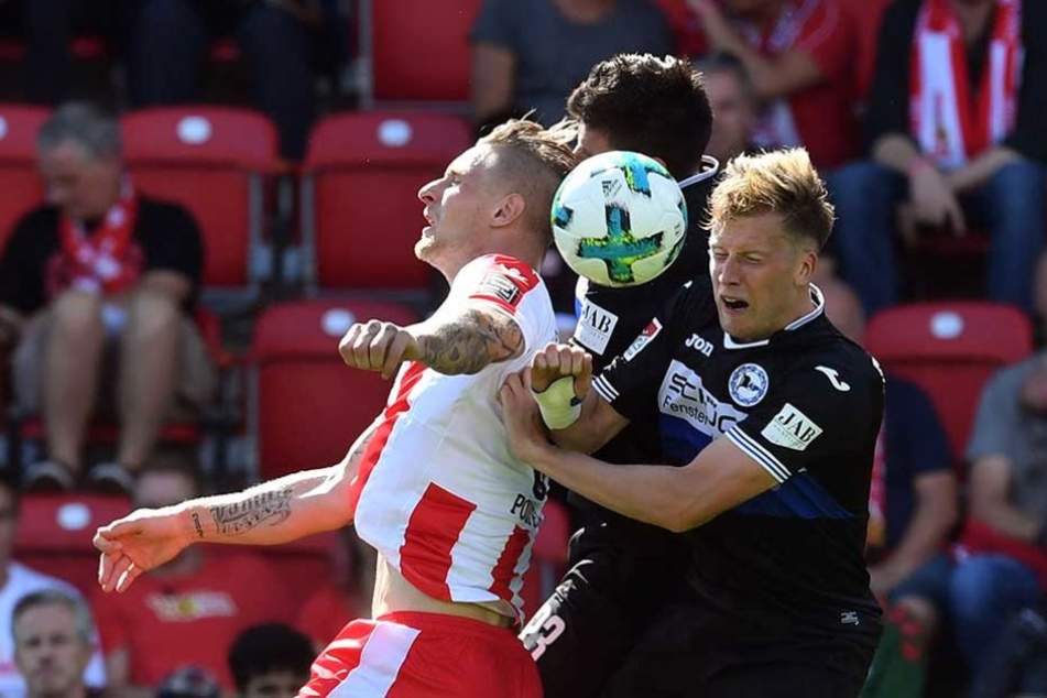 Sebastian Polter (l) vom 1.FC Union Berlin gegen Florian Dick (M) und Christoph Schösswendter von Arminia Bielefeld.