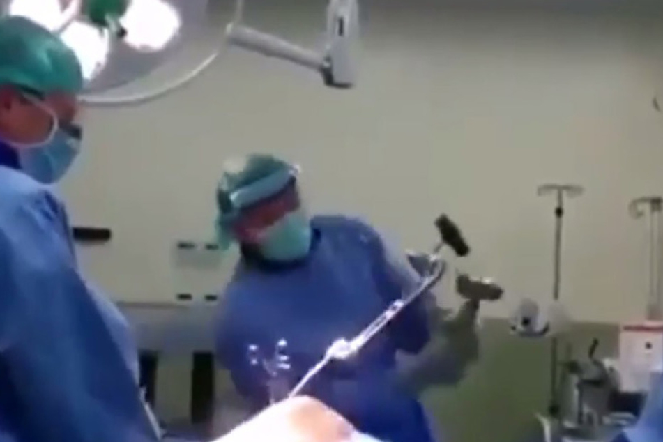 Diese Bilder lassen einen erschaudern: ein Arzt kloppt bei einer Operation mit einem Hammer auf eine Stange ein, die noch im Bein des Patienten befestigt ist.