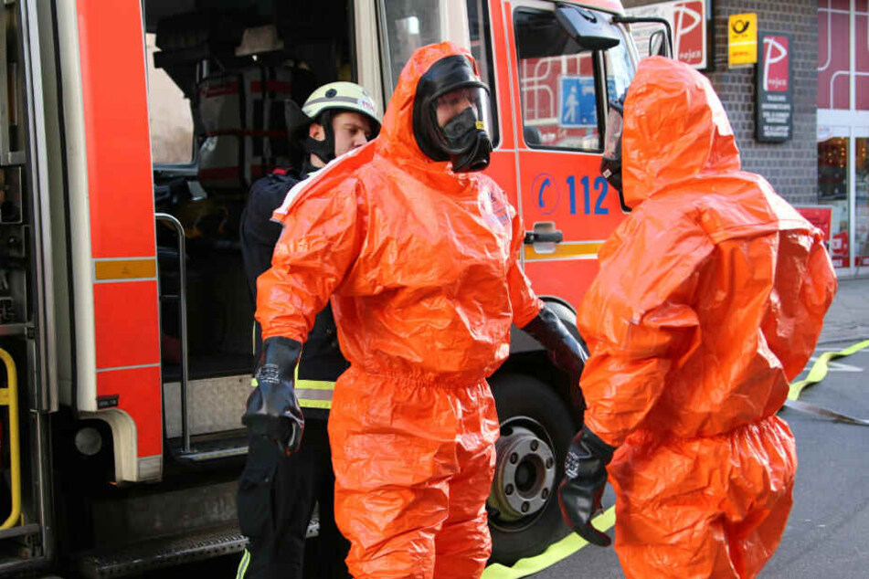 Feuerwehrmänner ziehen sich die Schutzanzüge über.