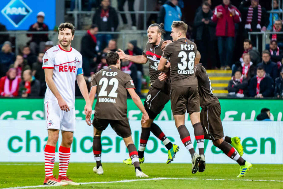 Kölns Jonas Hector (links) konnte nur zusehen, wie sich der FC St. Pauli und Torschütze Alex Meier (Mitte) über dessen Treffer freuten.