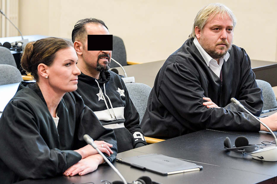 Der 30-jährige Angeklagte wartet zwischen seinen Anwälten Christian Lange (r) und Svenja Gruhnwald im Strafgerichtsgebäude auf den Beginn der Verhandlung.