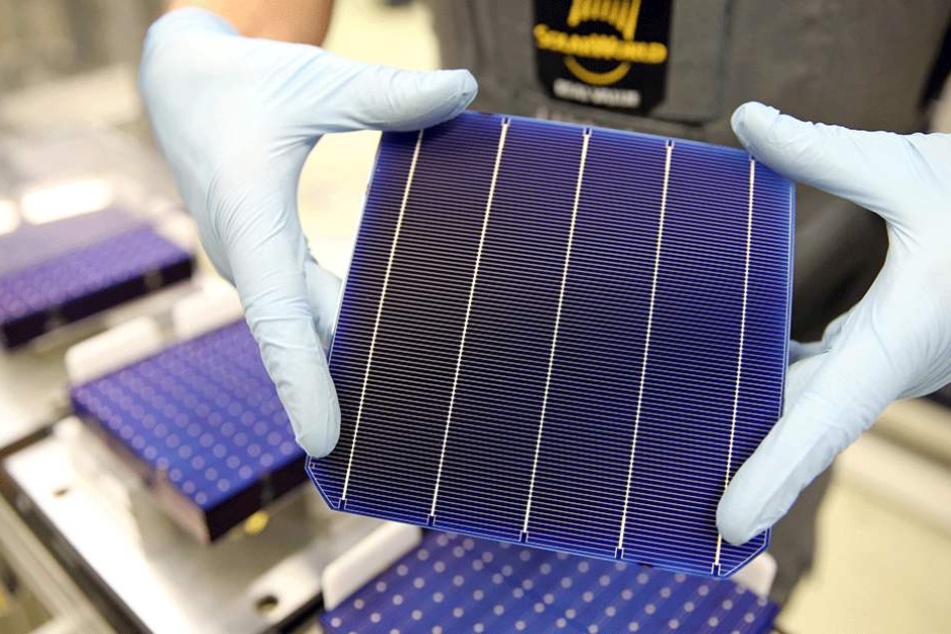in Mitarbeiter der Modulfertigung bei Solarworld zeigt eine sogenannte "PERC-Zelle".