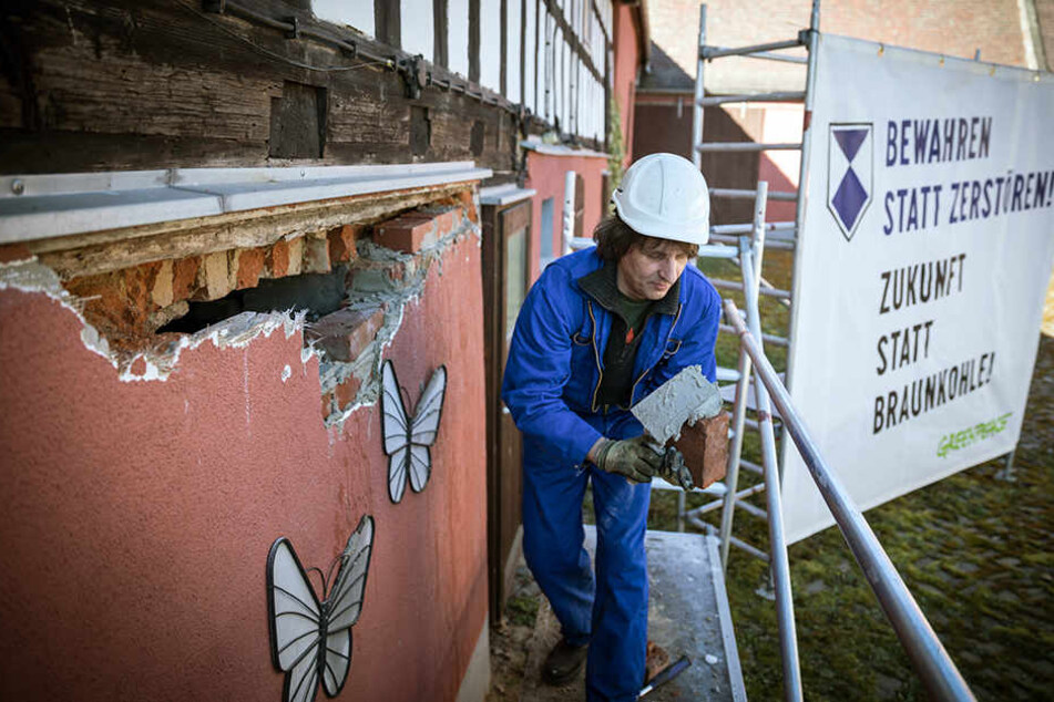 Aktivisten von Greenpeace reparierten am Montag Häuser in Pödelwitz, die der Mibrag gehören und sorgten so für einen Polizeieinsatz.