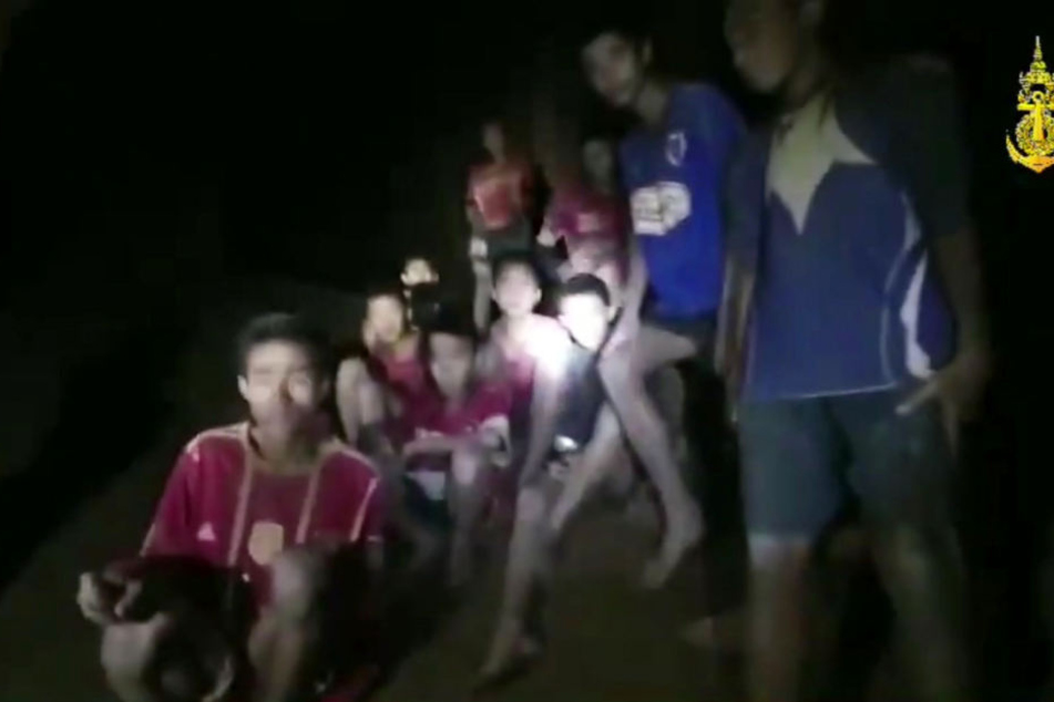 Eine der Thai Navy Seals zur Verfügung gestellte Aufnahme zeigt die vermissten Jugendfußballer und ihren Trainer, nachdem sie in einer Höhle entdeckt wurden.