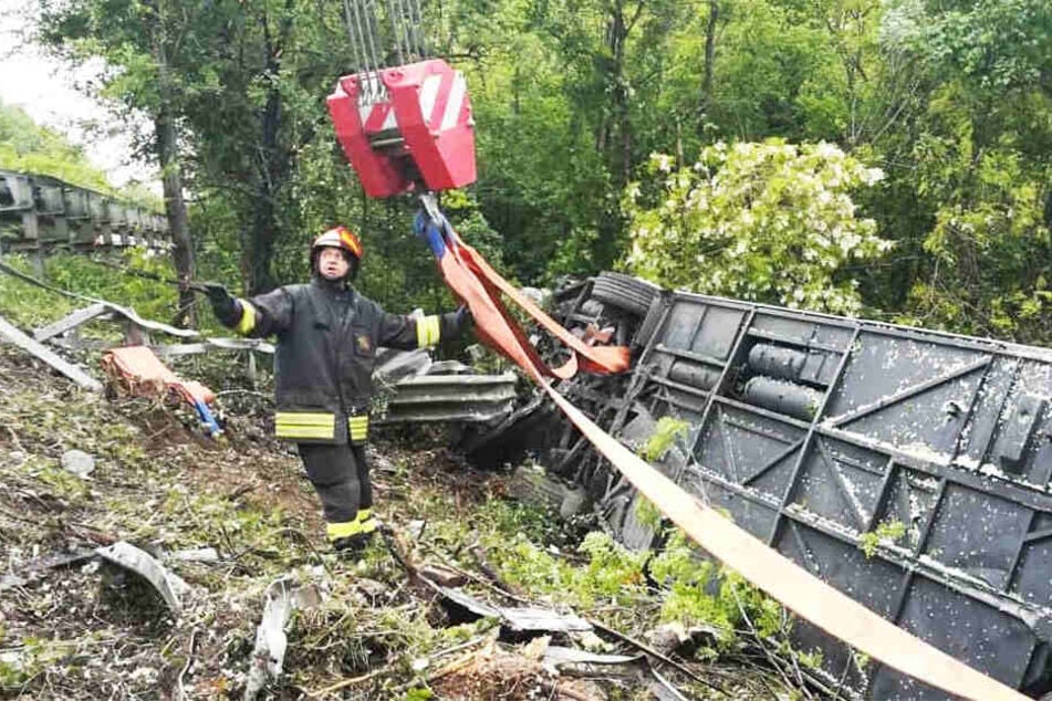 Fotos der Feuerwehr zeigen den verunglückten Bus an einem Abhang in der Böschung.